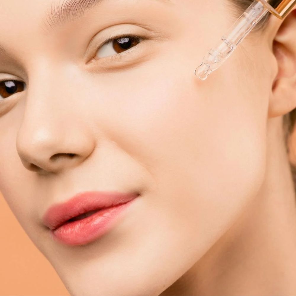 Hình ảnh cô gái đang sử dụng serum lên mặt