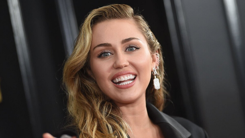 miley cyrus đeo bông tai màu trắng đang cười