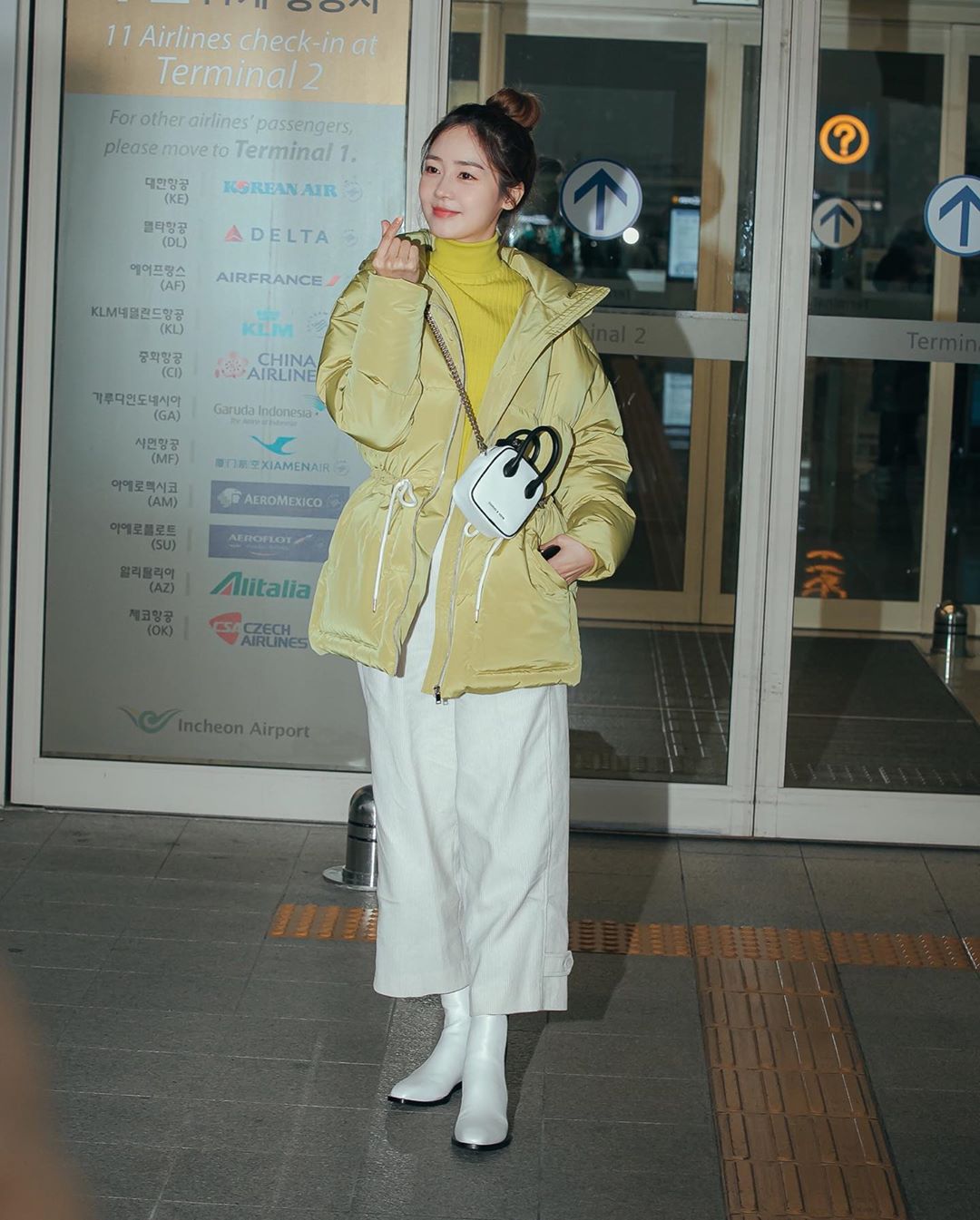 Sung Yuri áo cổ lọ màu vàng chanh và boots trắng
