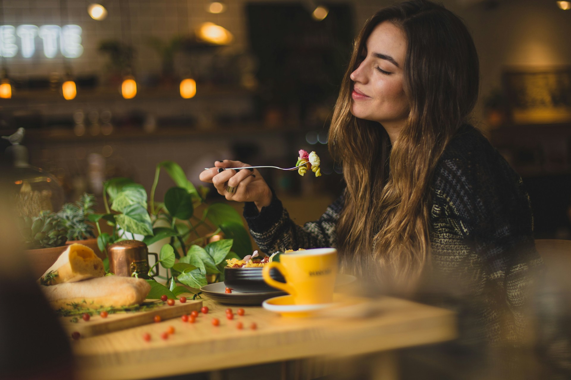 Cô gái đang ăn salad trái cây ở quán cà phê có pizza