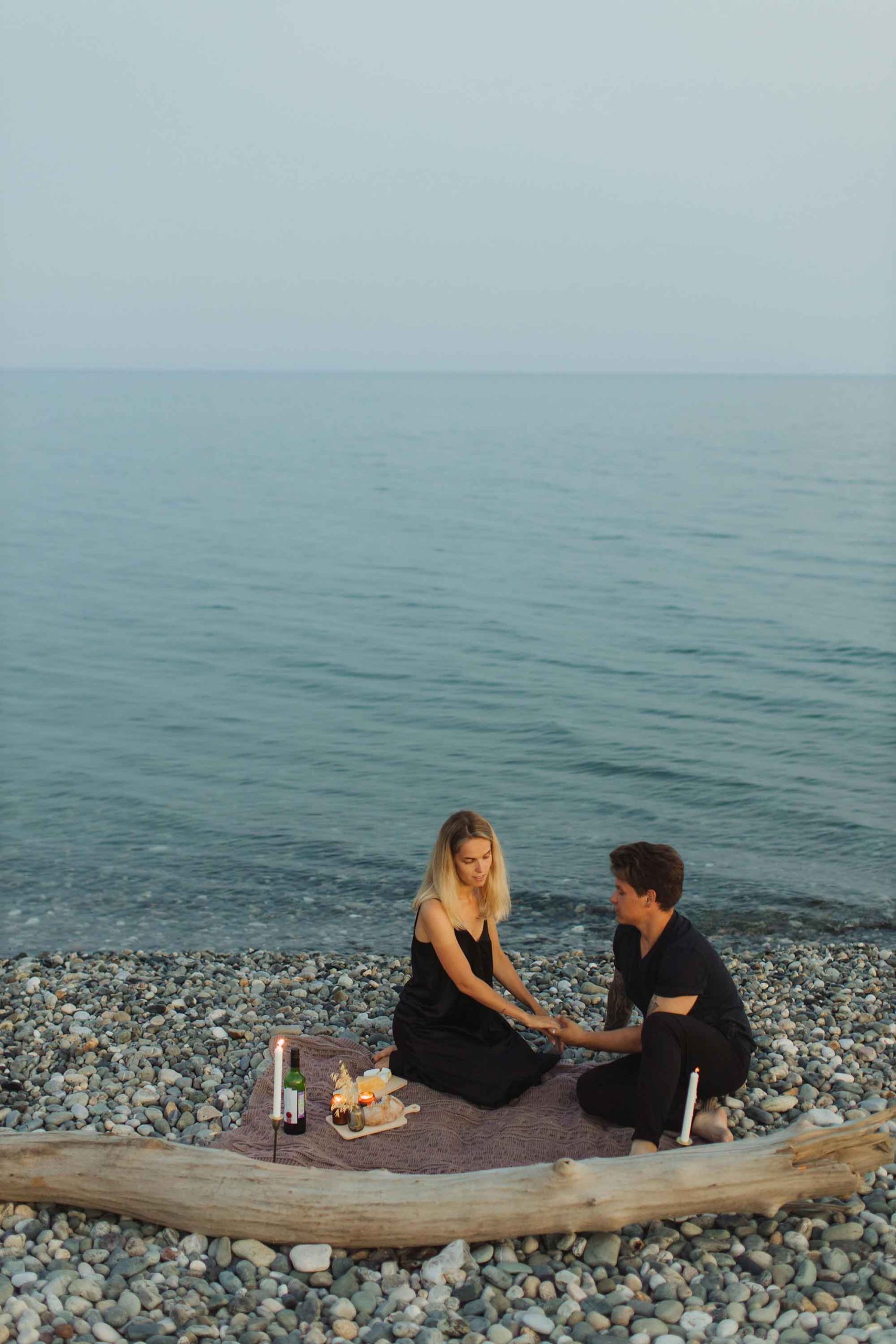 cặp đôi cung hoàng đạo ngồi bên bờ biển hẹn hò