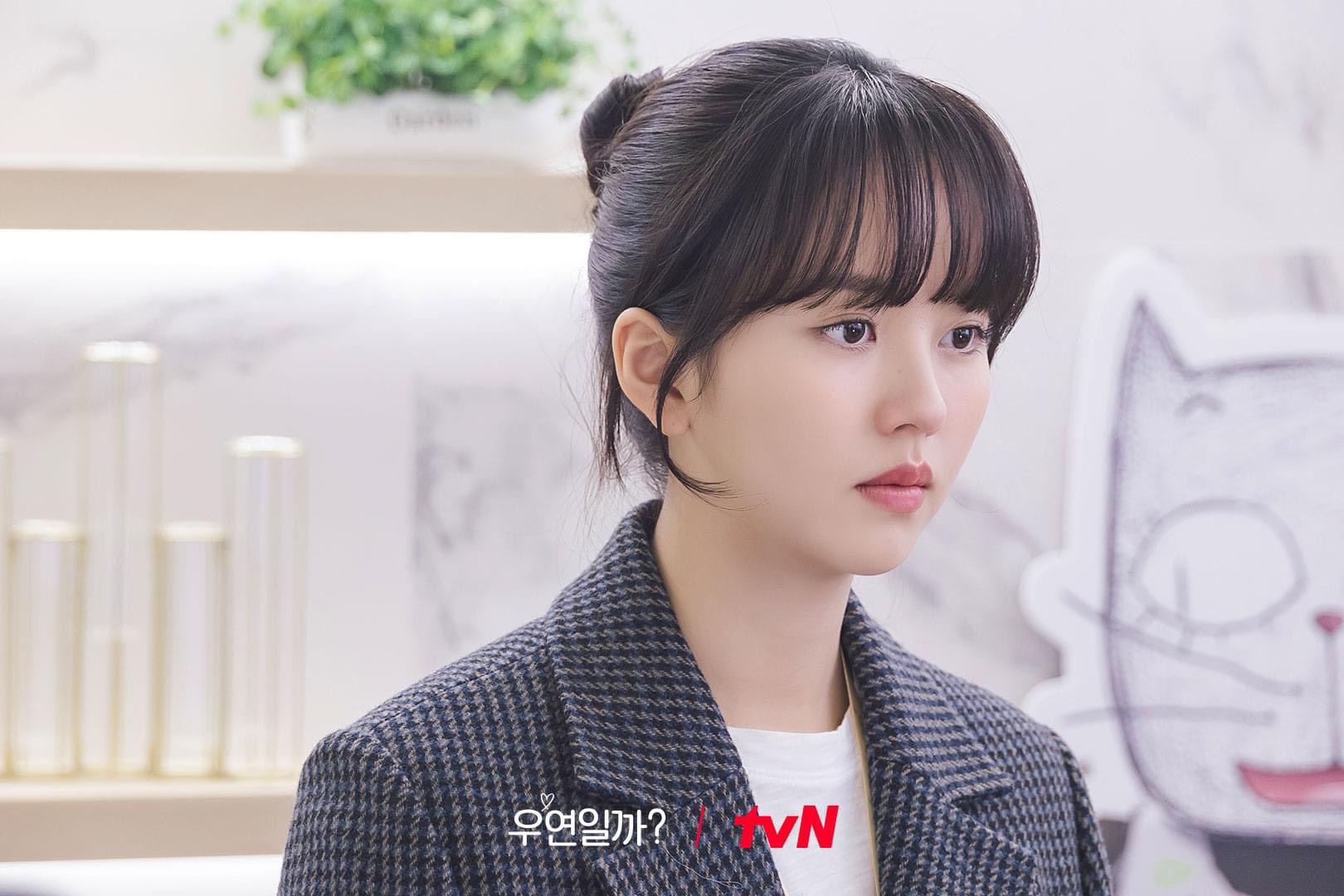 Kim So Hyun mặc blazer màu xám, tóc búi cao và để mái thưa chụp hình chân dung