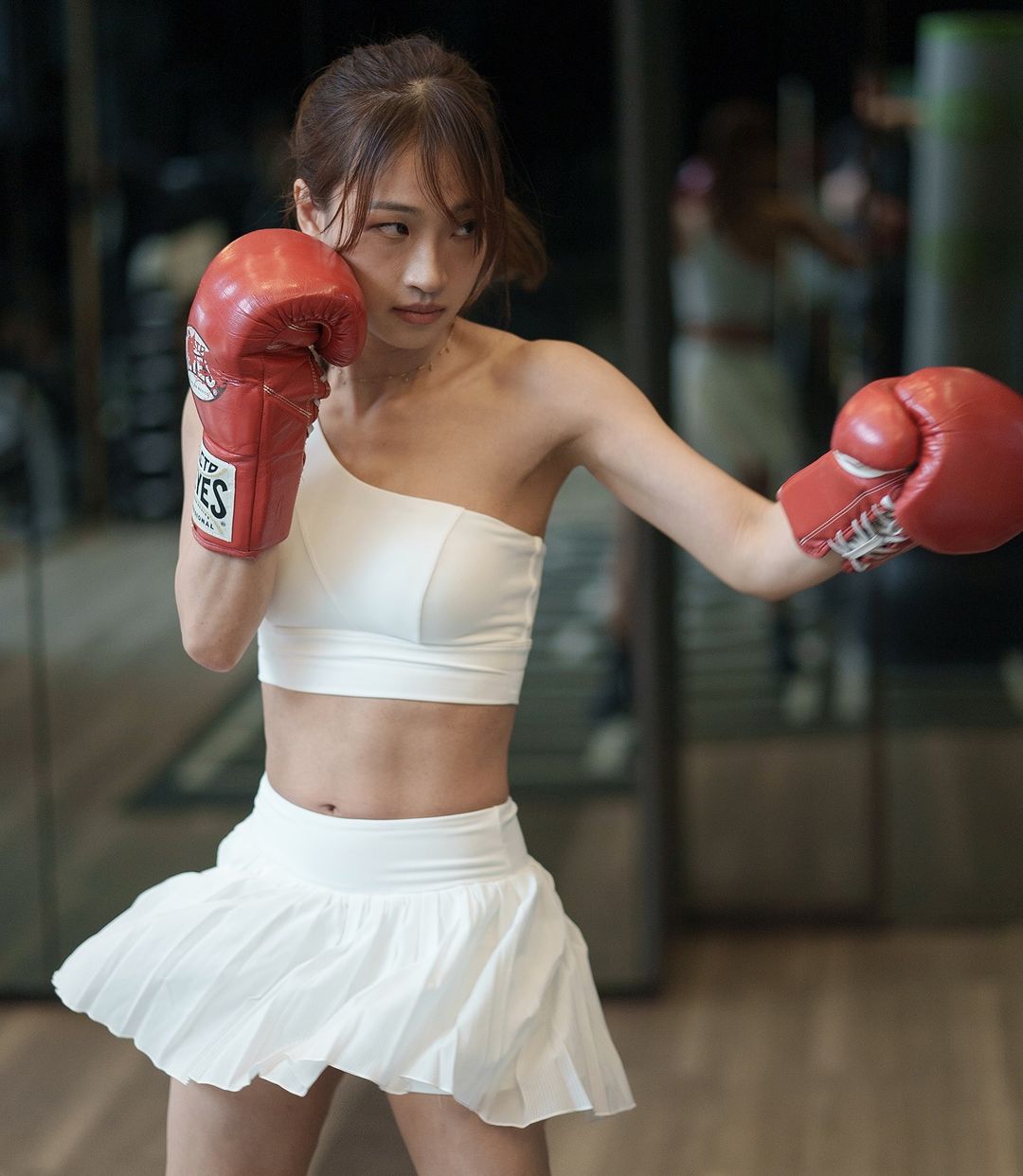 cô gái tập boxing trong bộ đồ thể thao trắng nữ tính