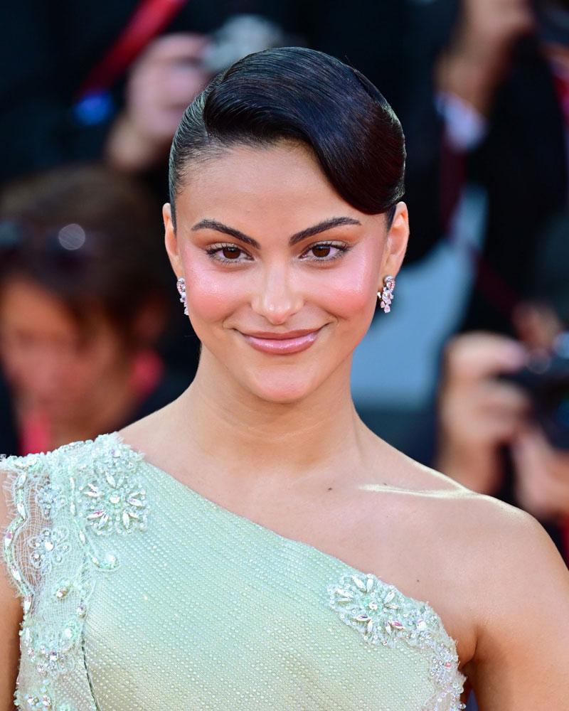 venice - diễn viên Camila Mendes mặc đầm lệch vai màu xanh, trang điểm tone nude và tạo kiểu tóc búi cao