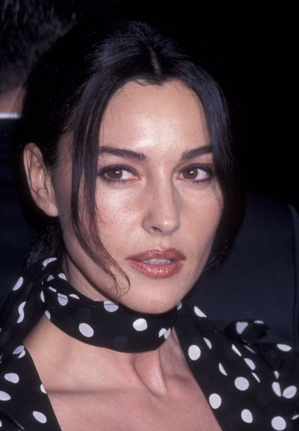 Monica Bellucci mặc áo họa tiết chấm bi và búi tóc cao để chụp ảnh chân dung