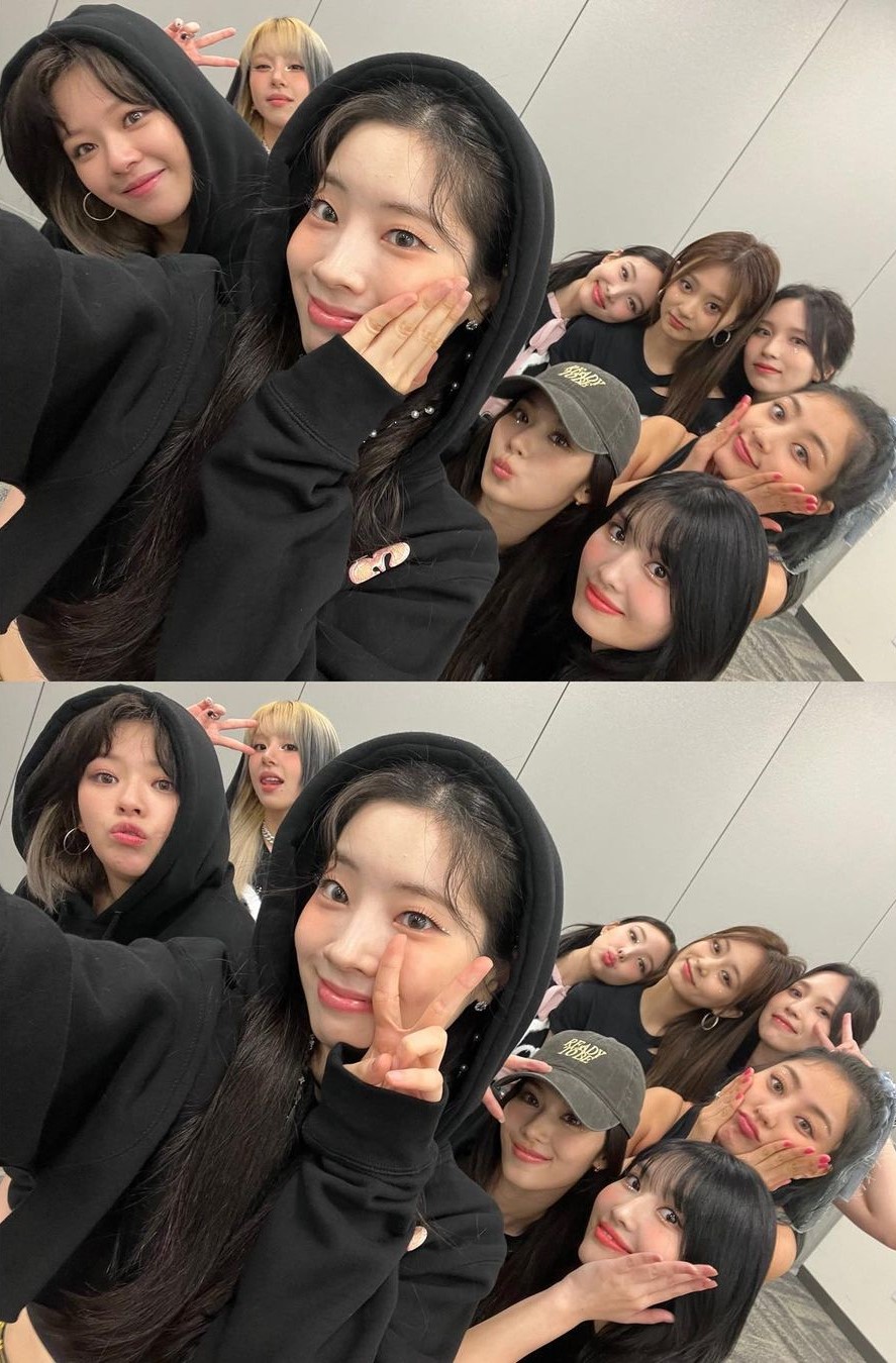 Twice mặc áo hoodie đen và tạo dáng để selfie