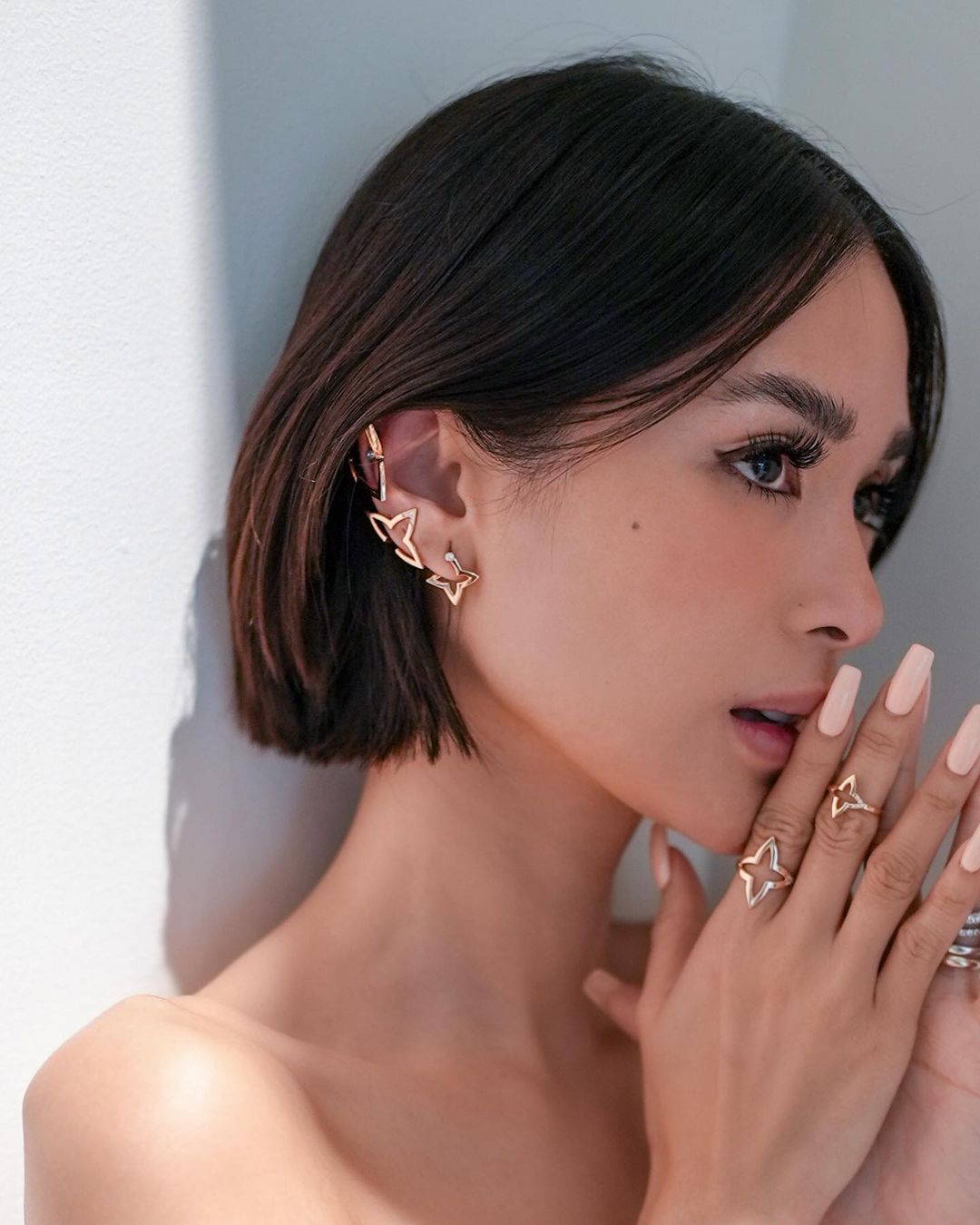 Heart Evangelista diện tóc bob và đeo khuyên tai, nhẫn màu vàng có họa tiết ngôi sao 4 cánh